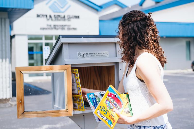 Staff Filling Little Free Library Box with Books